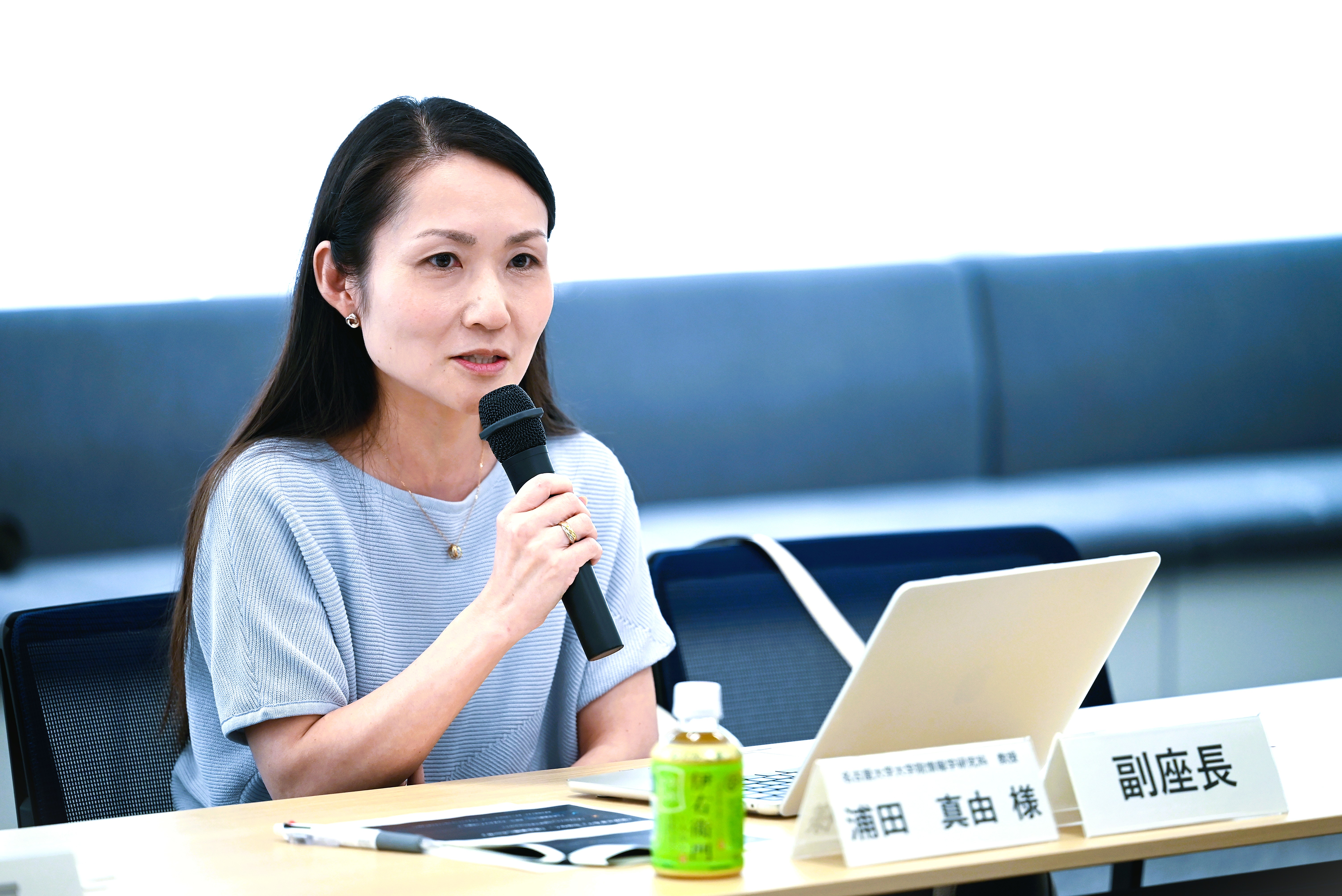 浦田教授がマイクを持って話している写真