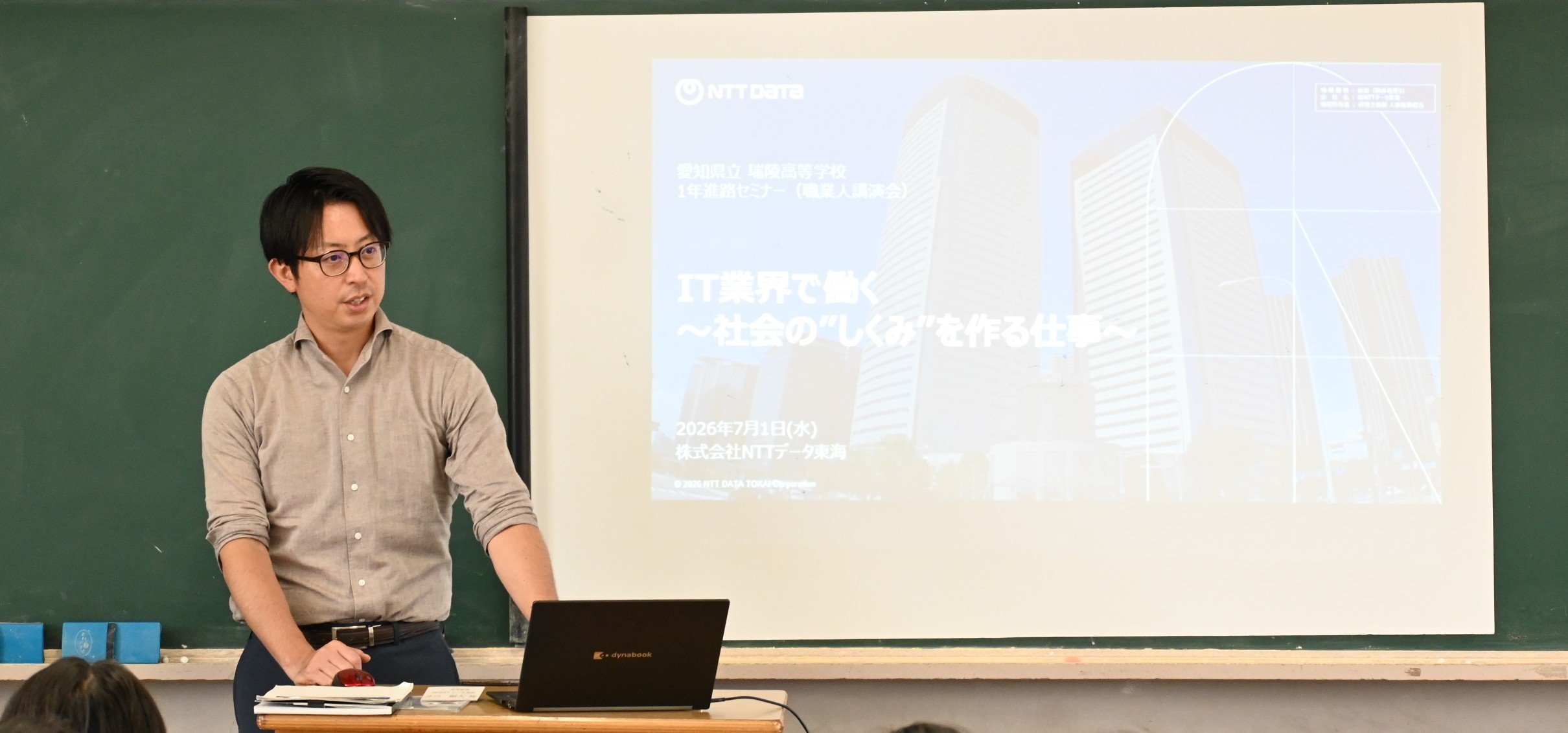写真：教室で登壇者がスライドを投影し、IT業界の仕事やキャリアについて参加者へ説明している講演の様子